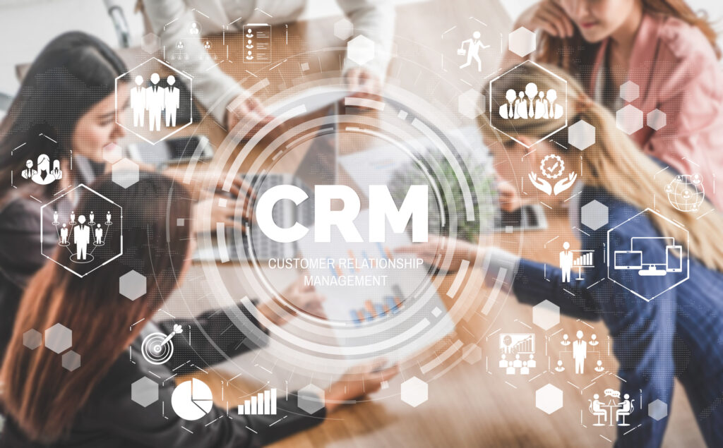 A business team discusses sales CRM tools around a desk