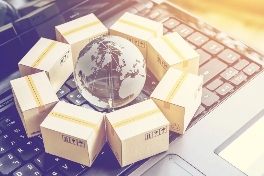 Boxes surrounding a globe on a laptop representing channel vs. direct sales