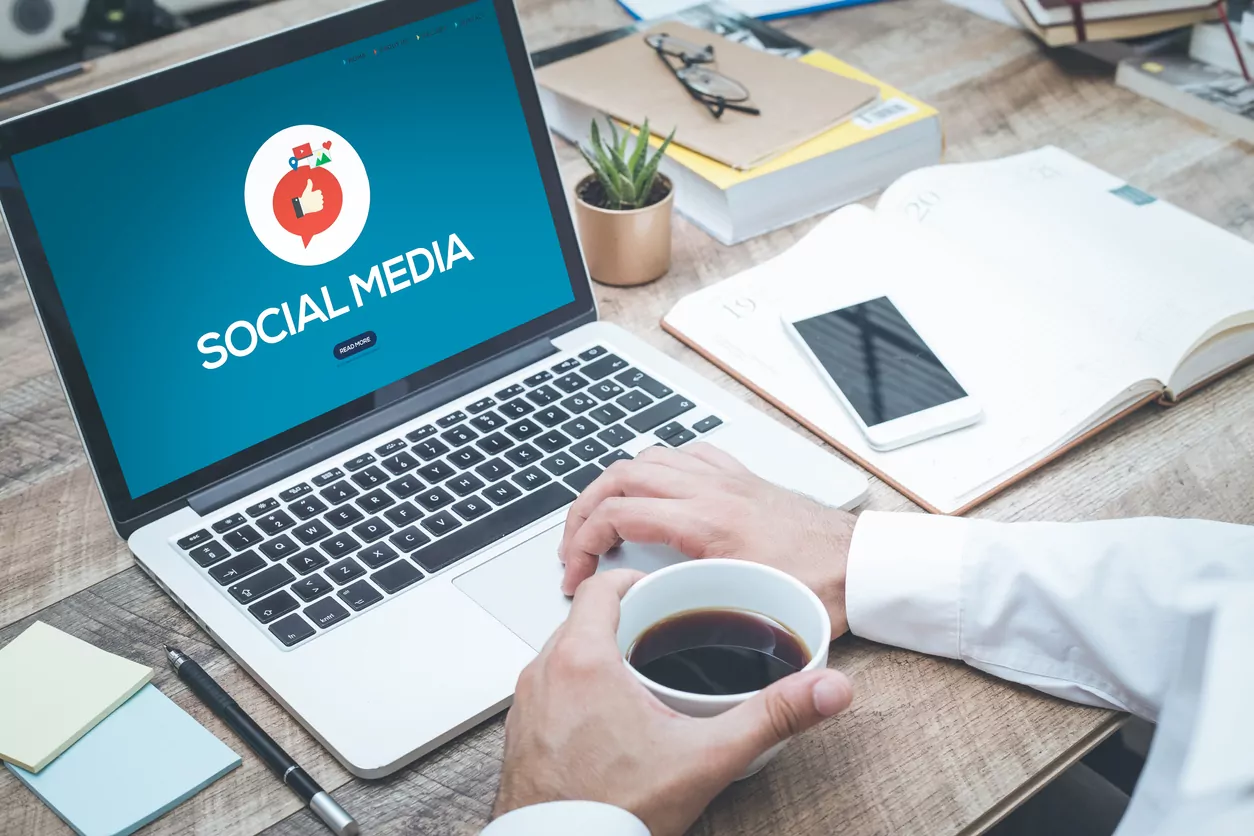 Person implementing social media advertising by creating a social media post.